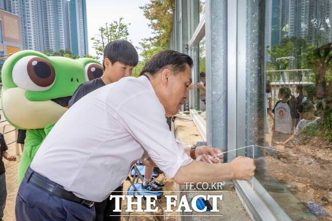 이재준 수원시장이 9일 송림초등학교 학생들과 함께 방음벽에 야생조류 충돌방지 테이프를 붙이고 있다./수원시