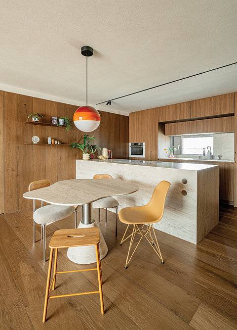 천연 트래버틴 대리석을 활용해 내추럴한 분위기를 강조한 아일랜드 테이블과 식탁. 식탁 상판은 유려한 곡선으로 디자인해 그 자체로 하나의 오브제와 같다.&nbsp;