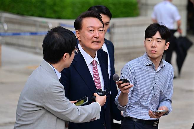 윤석열 전 대통령이 9일 오후 서울 서초구 중앙지방법원에서 열린 내란 우두머리 혐의, 직권남용 권리행사방해 혐의 사건 6차 공판을 마친 후 취재진의 질문을 받으며 법원을 나서고 있다./뉴스1