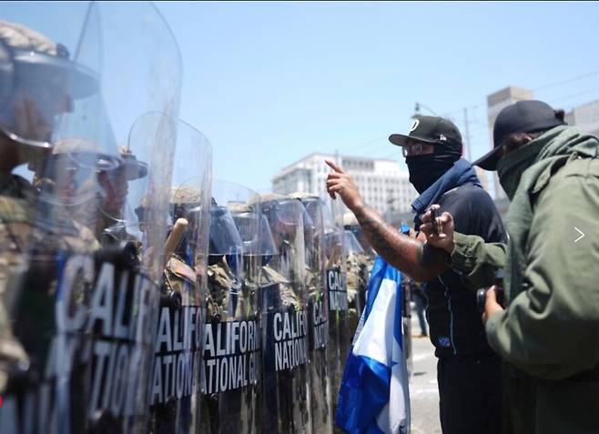 미국 캘리포니아주 로스앤젤레스(LA)에서 불법 이민자 단속에 항의하는 시위가 격해진 가운데 도널드 트럼프 미국 대통령이 시위 진압을 위해 투입한 주방위군 2000명에 관심이 쏠린다. 사진은 지난 8일(현지시간) LA에 투입된 주 방위군이 마스크를 쓴 이민자 강제 추방 반대 시위대와 대치하는 모습. /사진=뉴시스