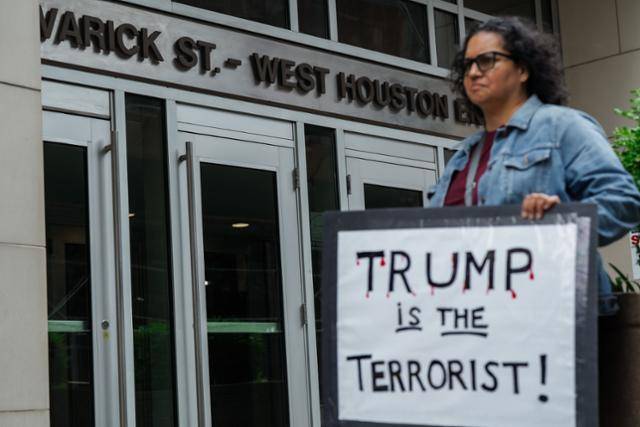 한 시민이 지난달 28일 미국 뉴욕시의 연방 정부 건물 앞에서 "트럼프는 테러리스트"라는 팻말을 들고 시위를 벌이고 있다. 뉴욕=EPA 연합뉴스