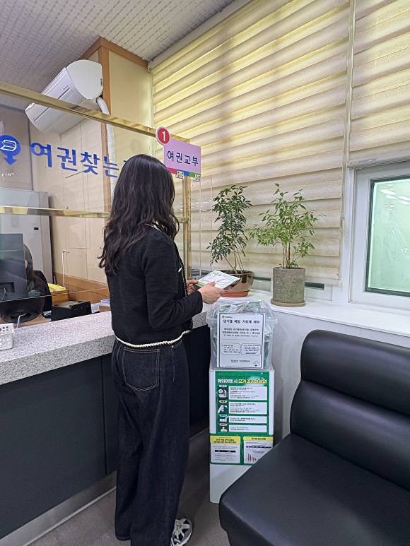 민원인이 시청 민원여권팀에 비치된 모기 기피제와 예방수칙 안내문을 보고있다 [사진=경산시]