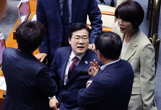 박찬대 더불어민주당 대표 권한대행 겸 원내대표(가운데)가 5일 국회 본회의장에서 동료 의원들과 대화하고 있다. 임현동 기자