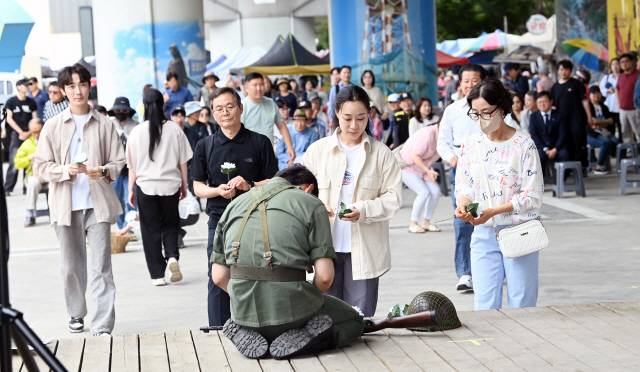 ▲ 이날 공연한 극중 주인공인 6·25참전호국영웅에게 시민들이 국화를 헌화하고 있다. 서영 기자