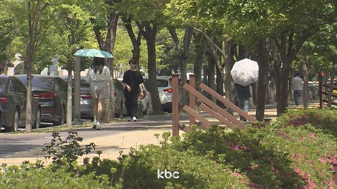 ▲ 무더위 속 양산을 쓴 채 걷는 시민들