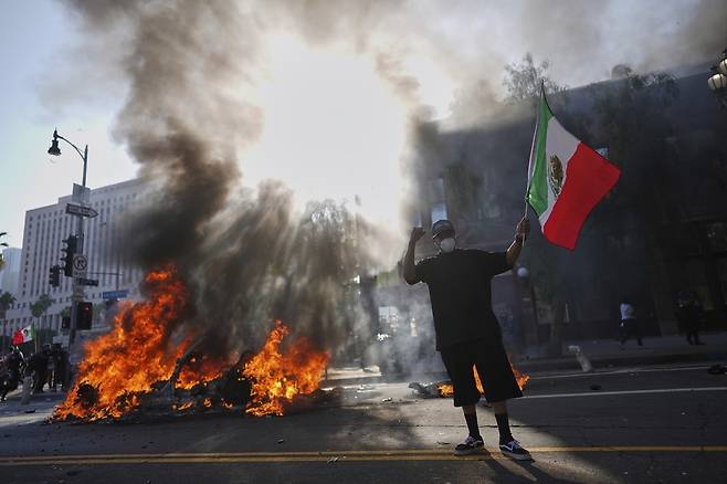 8일(현지시간) 로스앤젤레스 시내 메트로폴리탄 구치소 인근에서 웨이모(Waymo) 택시 한 대가 불타고 있다. AP연합뉴스