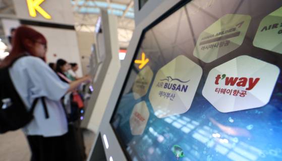 Travelers use the self-check in kiosks for low-cost carriers at Incheon International Airport's Terminal 1 on June 8, 2024. [YONHAP]