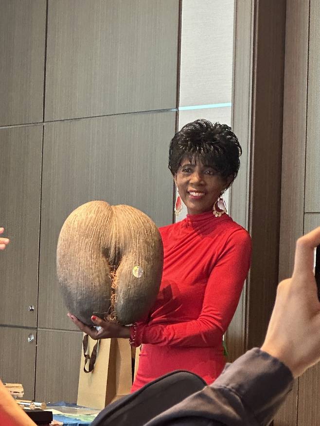 코코 드 메르 열매를 들고 있는 조바노빅-데시르 매니저.  /사진= 강예신 여행+ 기자