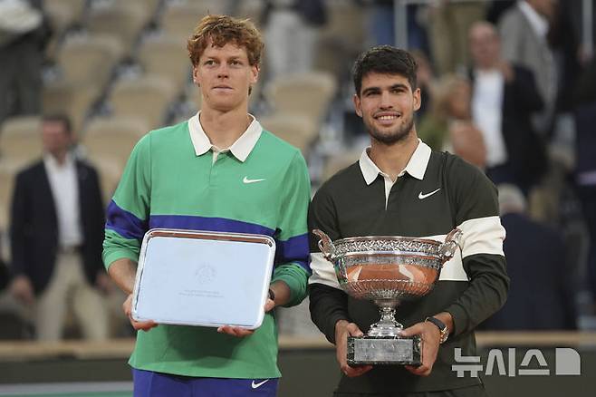 [파리=AP/뉴시스] 카를로스 알카라스(2위·스페인, 오른쪽)가 8일(현지 시간) 프랑스 파리 롤랑가로스에서 열린 프랑스오픈 남자 단식 정상에 올라 트로피를 들고 얀니크 신네르(1위·이탈리아)와 기념 촬영하고 있다. 알카라스는 결승전에서 신네르와 5시간 29분 대접전 끝에 3-2(4-6 6-7 6-4 7-6 7-6) 역전승을 거두고 대회 2연패를 달성했다. 2025.06.09.