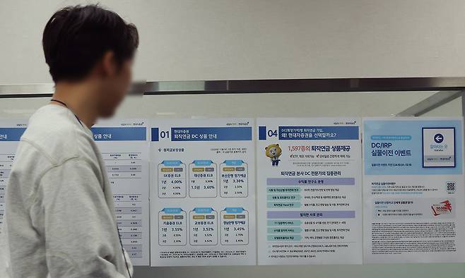 서울 한 증권사 영업점에서 관계자가 관련 홍보물을 부착하는 모습. 연합뉴스