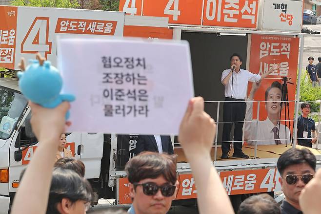 지난 5월 30일 이준석 개혁신당 대선후보가 서울 동작구 중앙대에서 유세 중인 가운데 일부 학생들이 혐오 정치를 규탄하는 팻말을 들고 있다. 연합뉴스