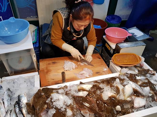 물회의 재료가 되는 생선을 썰고 있는 죽도시장 상인.
