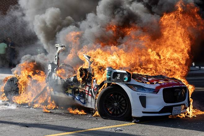 LA 시위대의 방화로 불타고 있는 웨이모 자율주행택시.(사진=AFP)