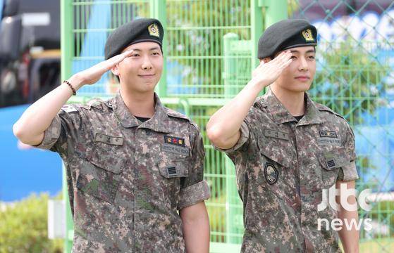 방탄소년단(BTS) 멤버 RM(왼쪽)과 뷔가 만기 전역 후 취재진 앞에서 이야기를 나누고 있다. 〈사진=JTBC엔터뉴스〉