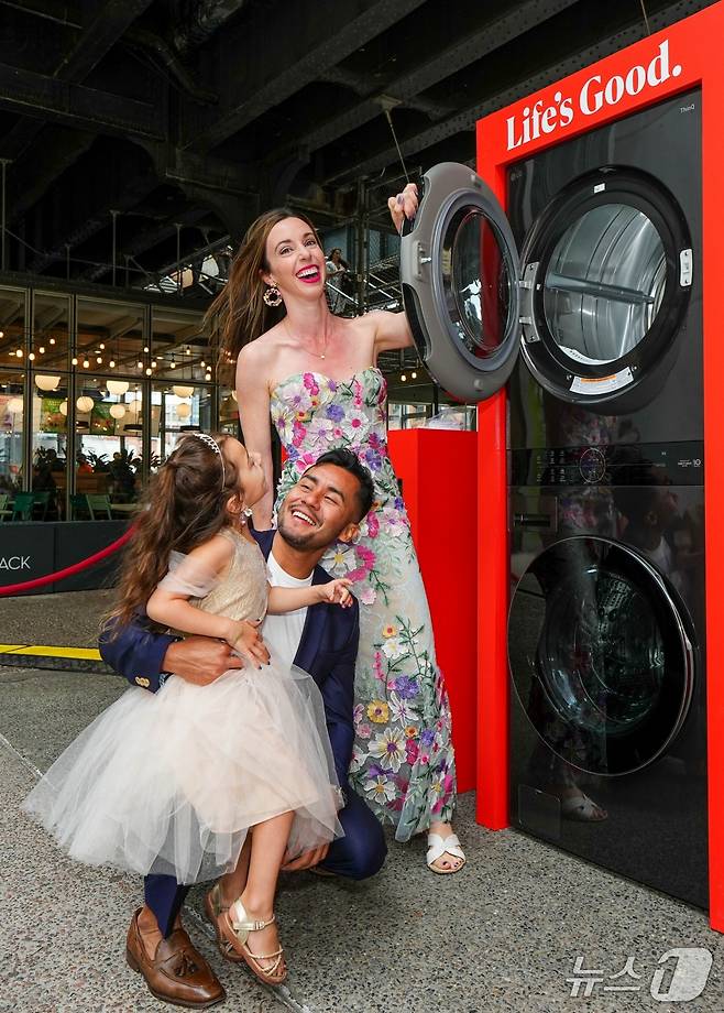 LG전자가 최근 미국 뉴욕의 하이라인 파크에 스테인드글라스 무늬로 장식된 워시타워로 디자인한 공간을 마련하고, 총 10쌍의 연인이 이곳에서 결혼 서약식을 진행하도록 지원하는 '러브 투 런더리(Love to laundry)' 행사를 열었다. 사진은 결혼 서약식의 주인공이 된 참가자들이 LG전자의 복합형 세탁건조기 '워시타워' 앞에서 기념 사진을 촬영 중인 모습. (사진제공 = LG전자)