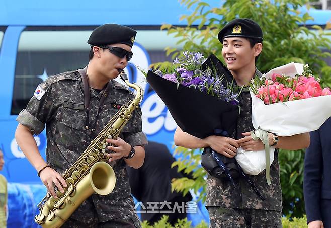 방탄소년단(BTS)의 RM(왼쪽, 김남준)이 10일 강원도 춘천시 신북읍 체육공원에서 진행된 전역 행사에서 색소폰을 연주하며 뷔(김태형)와 함께 행사장으로 입장하고 있다.  춘천 | 박진업 기자 upandup@sportsseoul.com