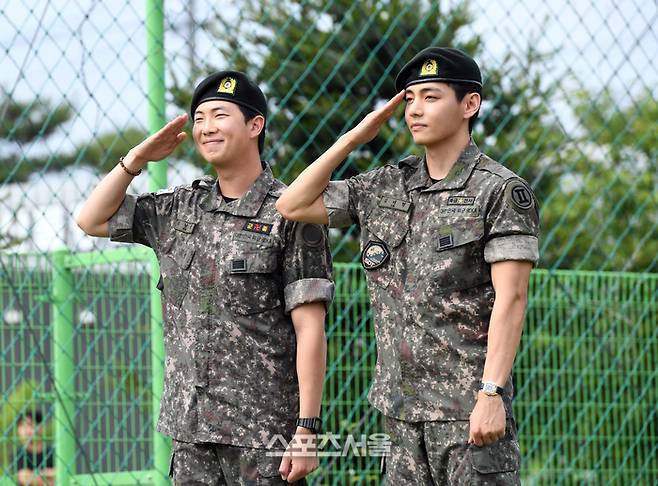 방탄소년단(BTS)의 RM(왼쪽, 김남준)과 뷔(김태형)가 10일 강원도 춘천시 신북읍 체육공원에서 진행된 전역 행사에서 팬과 취재진을 향해 거수 경례를 하고 있다. RM은 육군 제15보병사단 군악대에서, 뷔는 2군단 군사경찰 특수임무대에서 1년 6개월 동안 군복무를 했다. 2025. 6. 10.  춘천 | 박진업 기자 upandup@sportsseoul.com