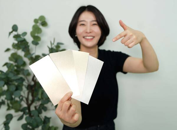 KCC 관계자가 실제 금속(왼쪽에서 두 번째)과 숲으로메탈릭을 칠한 종이(그 외 3개)를 비교하고 있다. ⓒKCC