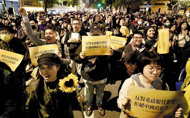 작년 '해바라기 운동 10주년' 기념하는 시민들 - 지난해 3월 18일 대만 타이베이 입법원(국회) 건물 밖에서 시민들이 해바라기와 피켓을 들고 '해바라기 운동' 10주년을 기념하고 있다. '해바라기 운동'은 2014년 보수 성향 국민당 정권이 중국과 체결한 '양안 서비스무역협정'을 졸속 통과시키려 하자 이에 항의해 벌인 청년들의 시위를 가리킨다. 대만 청년들이 정치에 관심을 많이 가지게 된 계기가 됐다고 평가된다. /EPA 연합뉴스