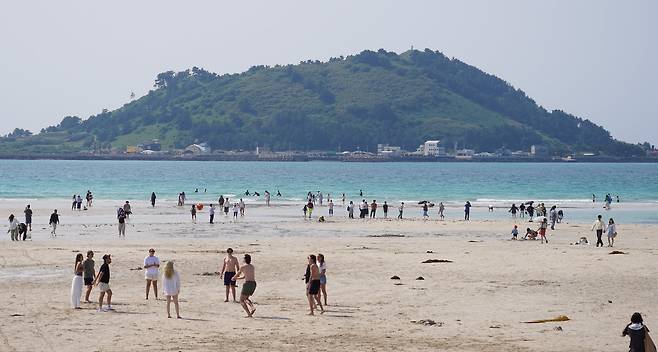 지난달 제주시 한림읍 협재해수욕장을 찾은 관광객들이 때 이른 여름 정취를 만끽하고 있다./뉴시스