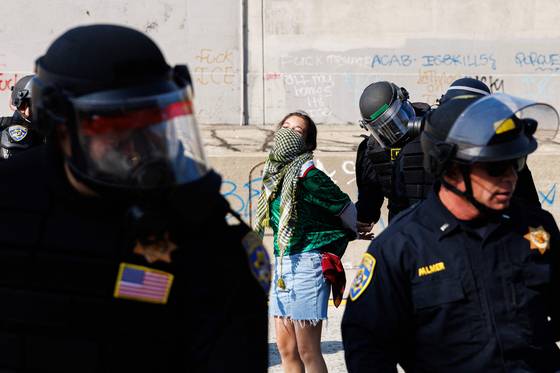 미국 로스앤젤레스(LA) 경찰이 8일(현지시간) LA 시내에서 불법 이민자 체포·추방에 반대하는 시위대를 체포하고 있다. AFP=연합