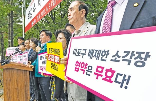 9일 서울 상암동 마포자원회수시설 앞에서 박강수 마포구청장과 손팻말을 든 주민들이 소각장 공동 이용 협약 개정 철회 및 추가 설치 반대 기자회견을 하고 있다.  뉴스1