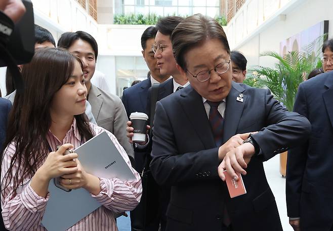 이재명 대통령이 10일 용산 대통령실 직원식당에서 식사를 마친 뒤 집무실로 돌아가며 취재진과 인사하다 시계를 들여다보고 있다. 대통령실사진기자단