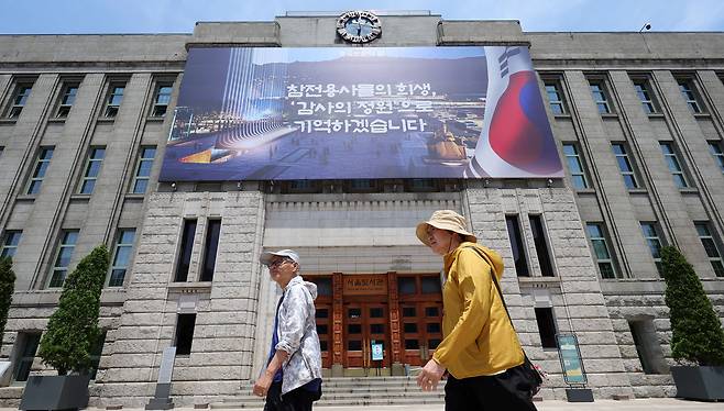 Pedestrians pass by the Seoul Metropolitan Library on Friday. (Newsis)