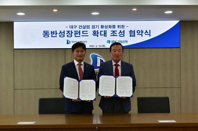 정명섭 대구도시개발공사 사장(오른쪽)과 이대홍 IBK기업은행 대구경북동부지역본부장이 10일 대구 건설업 경기 활성화를 위한 동반성장펀드 확대 조성 협약을 체결한 뒤 기념 촬영을 하고 있다. 대구도시개발공사 제공&nbsp;