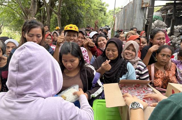 인도네시아 탕에랑 세완마을 주민들이 최근 마을 입구에서 선교사 부부가 나눠주는 도시락을 받아들고 있다.