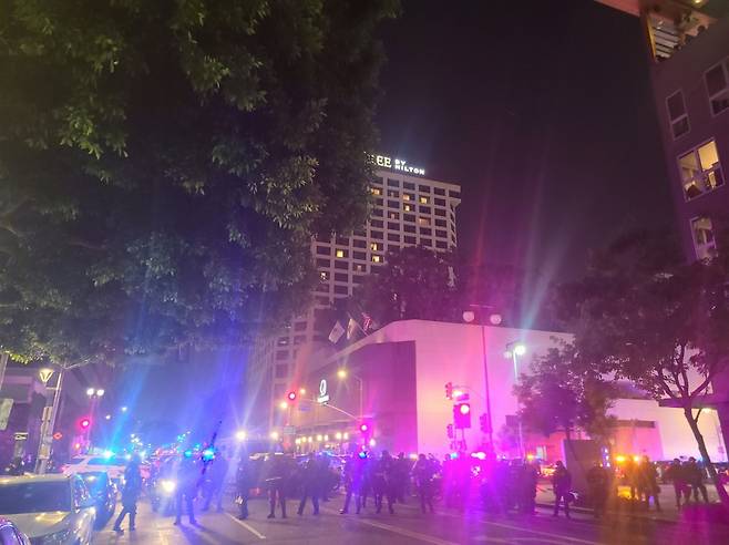 미국 캘리포니아주 로스앤젤레스 다운타운에서 9일(현지시간) 경찰관들이 시위대에 맞서 도로를 통제하고 있다.