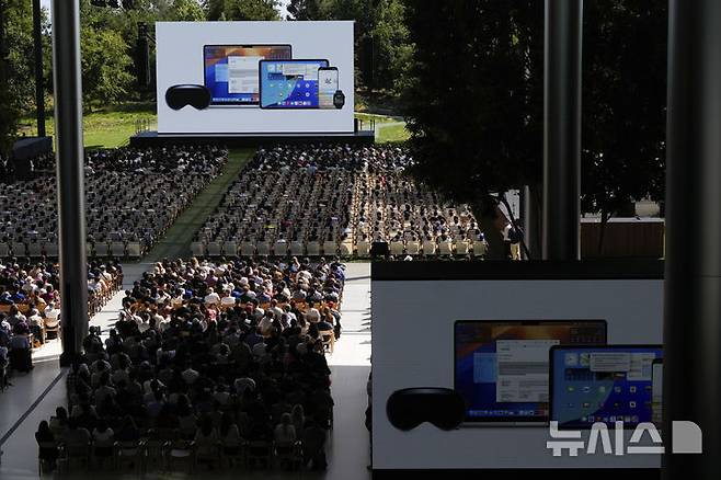 [쿠퍼티노=AP/뉴시스] 9일(현지 시간) 캘리포니아 쿠퍼티노 애플 캠퍼스에서 열린 WWDC 2025 행사 중 참석자들이 발표를 지켜보고 있다.