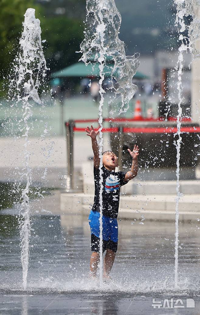 [서울=뉴시스] 김선웅 기자 = 서울 낮 최고기온이 30도를 기록한 9일 서울 종로구 광화문광장 분수대에서 한 어린이가 물놀이를 하며 더위를 식히고 있다. 2025.06.09. mangusta@newsis.com