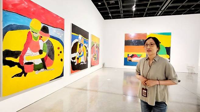 [사진=박현주미술전문기자]이정희 전시팀장이 션 스컬리가 아들과 부인과 함께 하는 그린 그림을 소개하고 있다. *재판매 및 DB 금지