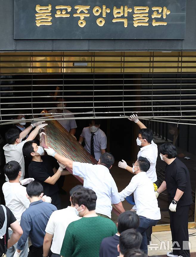 [서울=뉴시스] 김명년 기자 = 10일 오전 서울 종로구 조계사 옆 한국불교역사문화기념관 국제회의장에서 화재가 발생해 관계자들이 문화재를 옮기고 있다. 2025.06.09. kmn@newsis.com