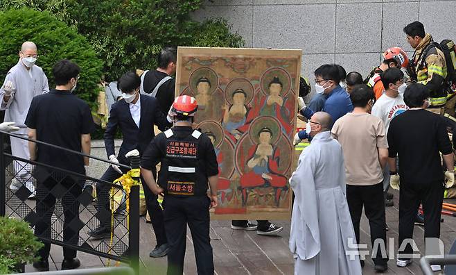 [서울=뉴시스] 김명년 기자 = 10일 오전 서울 종로구 조계사 옆 한국불교역사문화기념관 국제회의장에서 화재가 발생해 관계자들이 문화재를 옮기고 있다. 2025.06.09. kmn@newsis.com