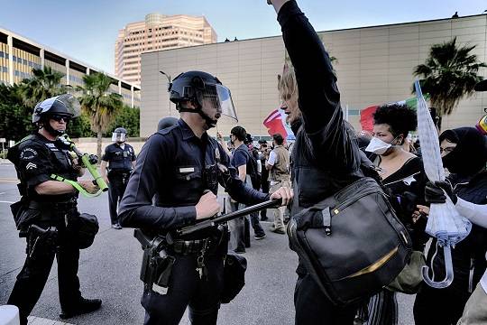 현지시각 9일 미국 캘리포니아주 로스앤젤레스(LA) 도심에서 LA 경찰이 이민세관단속국(ICE)의 불법 이민자 단속에 반대하는 시위대를 곤봉으로 밀어내고 있다. (출처=AP/뉴시스)
