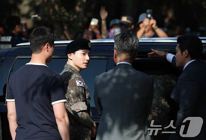 방탄소년단(BTS)의 정국이 11일 오전 경기도 연천군 연천공설운동장에서 군 복무를 마친 뒤 군복무를 마친 뒤 준비된 차량에 탑승하고 있다. ⓒ News1 권현진 기자
