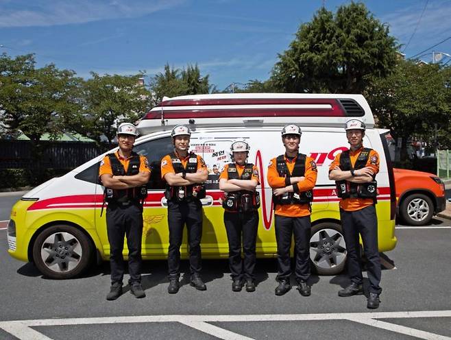 구급대원들이 구급차 안에서 임산부 긴급 분만 성공 단체 사진.