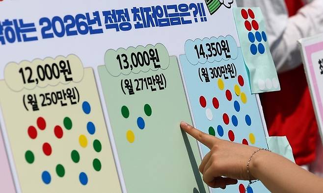 지난 14일 서울 종로구 광화문광장에서 전국서비스산업노동조합연맹 주최로 열린 ‘같이 살자! 최저임금! 오픈마이크\\\'에서 2026년 최저임금 적정 금액 설문이 이뤄지고 있다. 연합뉴스