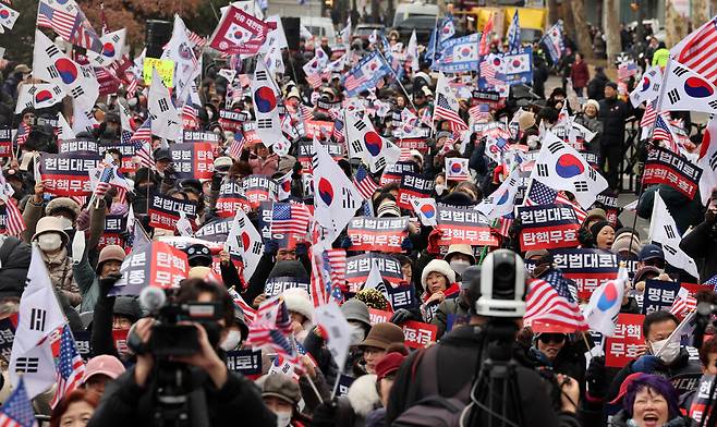대통령 윤석열의 탄핵심판 최종 변론 기일이 2025년 2월25일 오후 서울 종로구 헌법재판소에서 열리는 가운데 윤석열 지지 집회 참석자들이 손팻말과 태극기, 성조기를 흔들고 있다. 한겨레 김영원 기자
