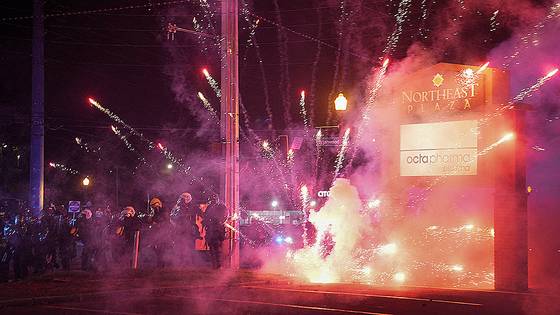 현지시간 10일 미국 조지아주 애틀랜타에서 시위를 진압하고 있던 경찰 병력 옆으로 시위대가 던진 폭죽을 터지고 있다. 로이터=연합뉴스