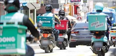 배달 라이더들이 줄지어 도로를 달리며 상품을 배송하는 모습.  한경DB