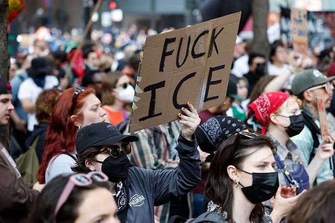 10일(현지시간) 미국 일리노이주 시카고에서 미등록 이민자 단속에 반대하는 시위대가 팻말을 들고 서있다. AFP연합뉴스