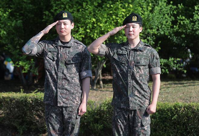 육군 현역 복무를 마치고 만기 전역한 그룹 방탄소년단(BTS)의 지민과 정국이 11일 경기도 연천군 연천공설운동장에서 취재진과 팬들을 향해 거수 경례하고 있다. 연합뉴스