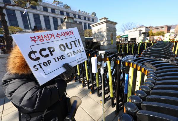 ▲서울 종로구 헌법재판소 앞에서 윤석열 대통령 지지자가 '부정선거 수사하라'는 구호가 적힌 피켓을 들고 있는 모습. 피켓에 중국공산당(CCP) OUT이라는 문구가 있다. ⓒ연합뉴스