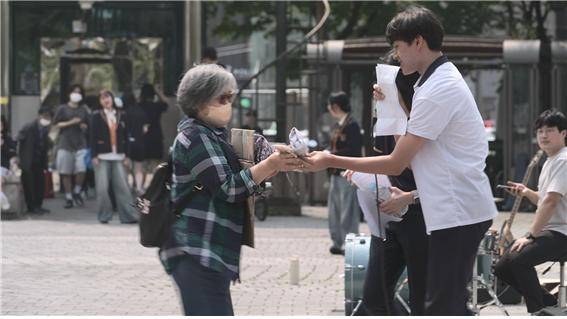 인천생활예술고 학생과 지역민 100여명은 지난달 30일 부평역 북광장에서 공연과 함께 기후 행동 캠페인 활동을 펼쳤다. 사진은 캠페인 활동 참여 학생이 한 시민에게 친환경 수세미와 EM 세수비누, 간식을 나눠주고 있는 모습 [인천생활예술고 제공]