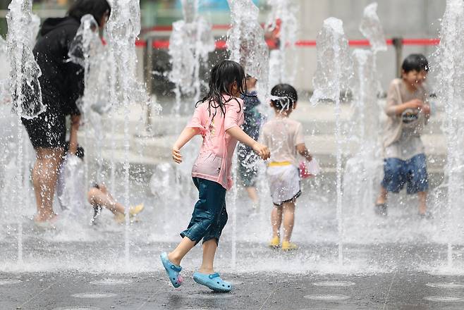 초여름 더위가 이어지고 있는 7일 서울 종로구 광화문광장에서 아이들이 물놀이를 하고 있다.[연합]