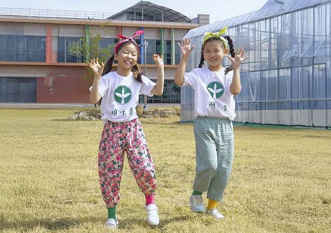 [칠곡=뉴시스] 몸빼바지에 새마을 티셔츠를 입고 '건강담은 칠곡할매 챌린지' 안무를 선보이는 김우리(왼쪽), 김민서 양. 앙증맞은 표정과 동작이 보는 이들의 미소를 자아냈다. (사진=칠곡군 제공) 2025.06.11 photo@newsis.com *재판매 및 DB 금지