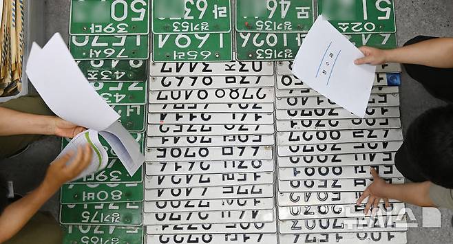 [의왕=뉴시스] 김종택 기자 = 체납차량 일제단속의 날인 27일 경기 의왕시청에서 징수과 지방세체납팀 직원들이 체납차량에서 영치한 자동차 번호판을 정리하고 있다. 2025.05.27. jtk@newsis.com